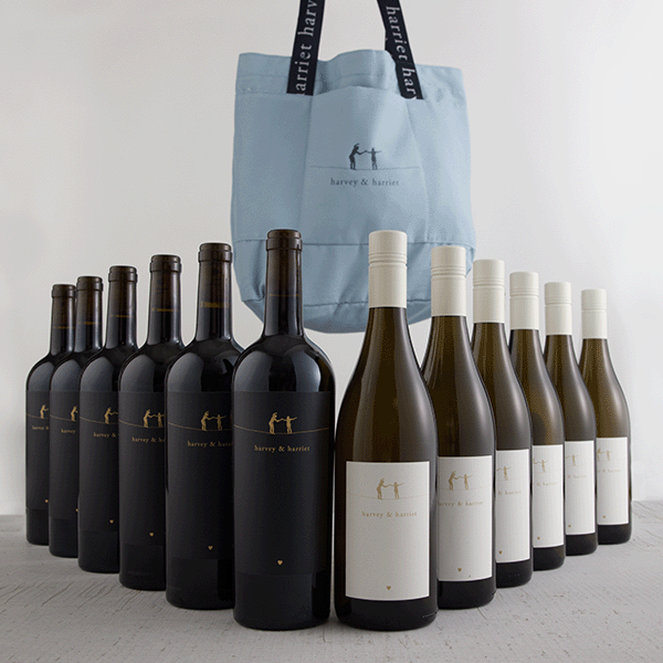 Collection of wine bottles with a blue tote bag featuring a brand logo on a light gray background